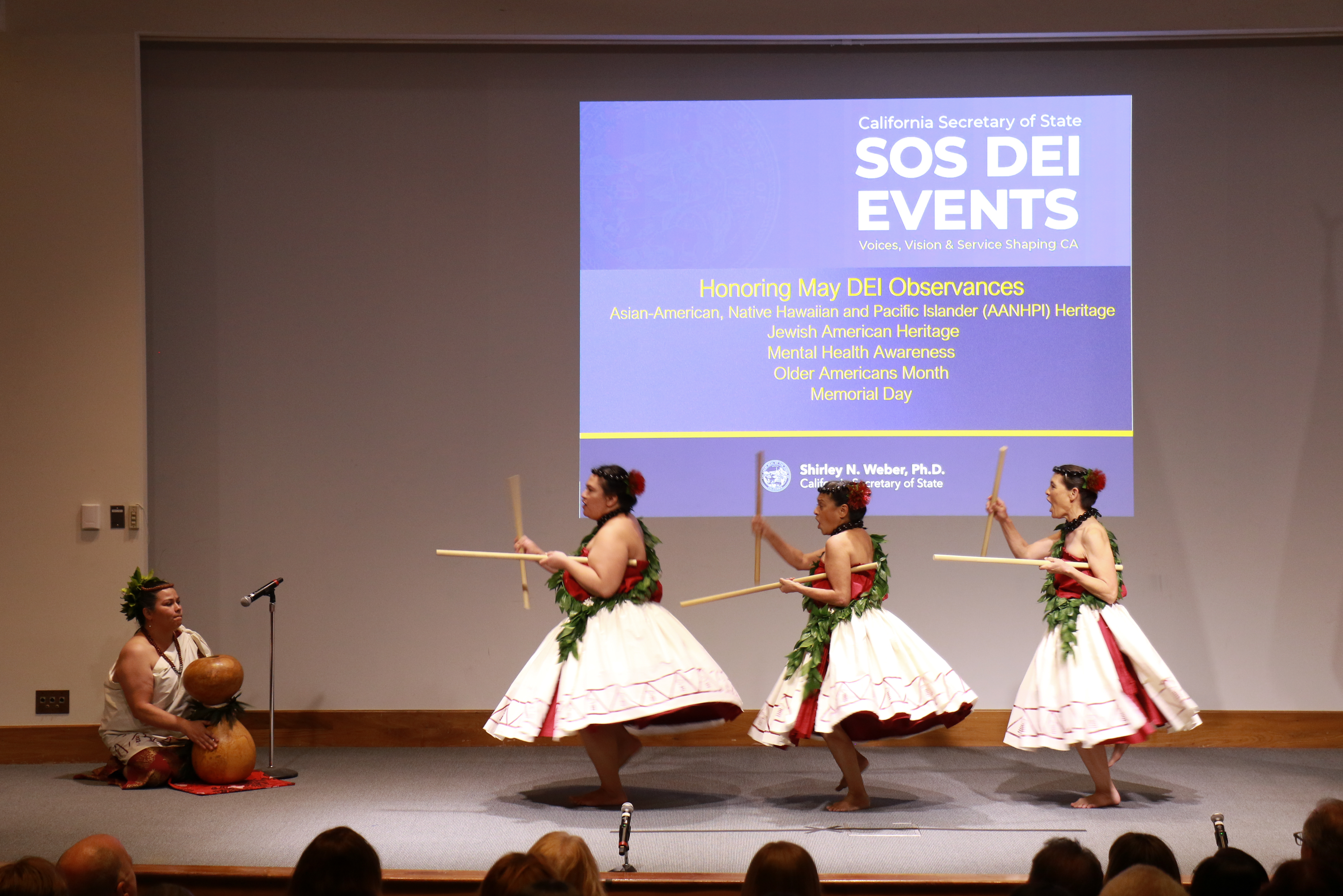 Four dancers perform on stage.